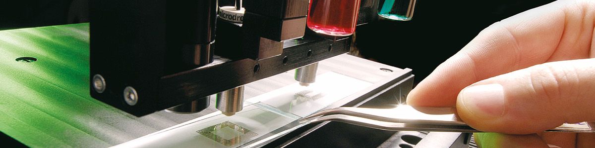 Microdispensing system placing droplets onto a microfluidic substrate