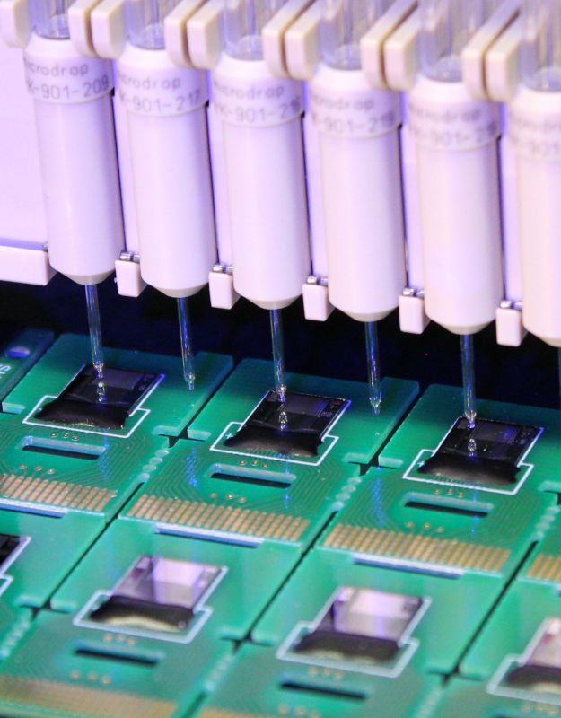 Multiple microdispenser nozzles dispensing onto biosensor and CMOS chip surfaces